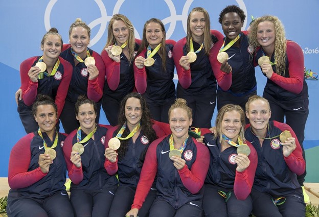 The USA women's water polo team stands to take a photo after winning medals.