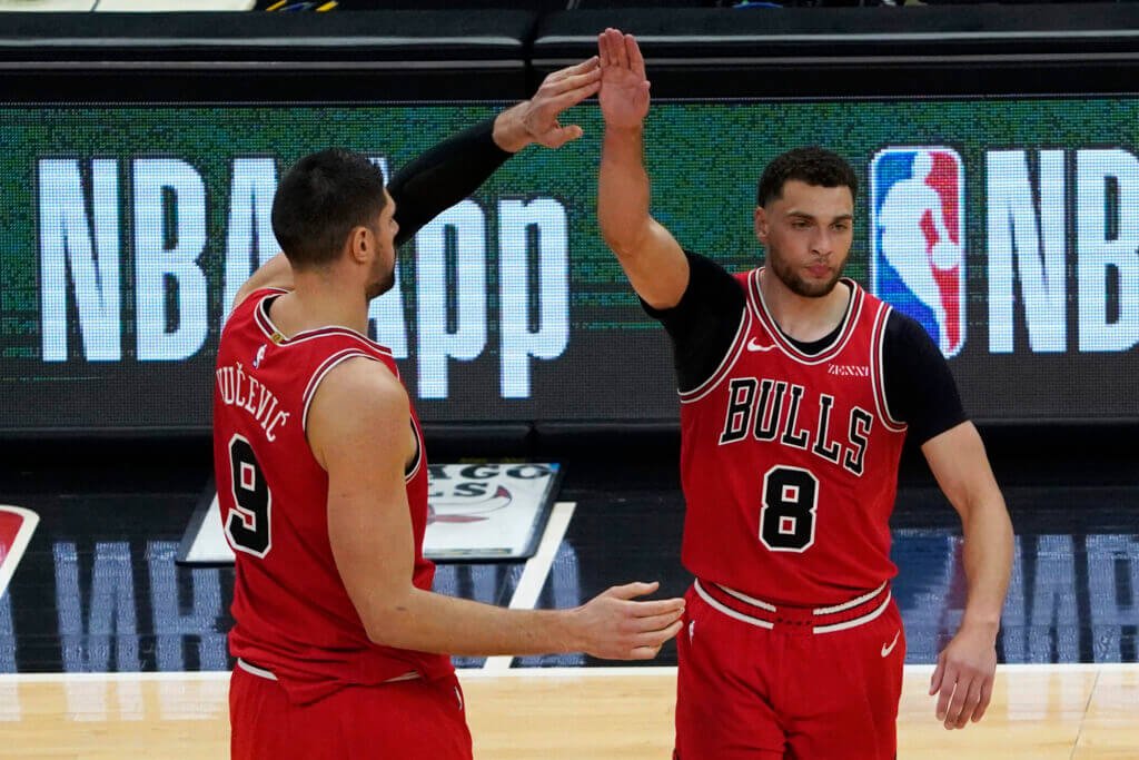 Zach Lavine and Nikola Vucevic high five during a Chicago Bulls' game.