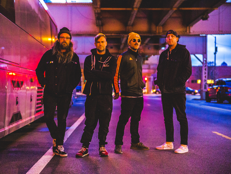 4 men standing with purple lights